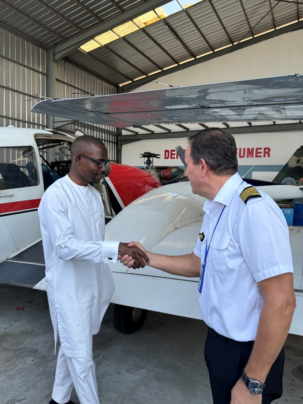 Le ministre de l'Environnement serrant la mainau pilote de l'avion.